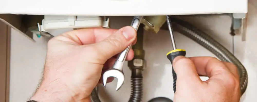 Boiler repair technician tightening pipe fittings and connections in Salt Lake City, UT