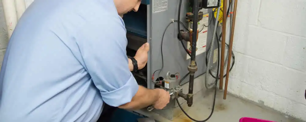 Furnace repair technician inspecting and servicing a home heating system in Salt Lake City, UT