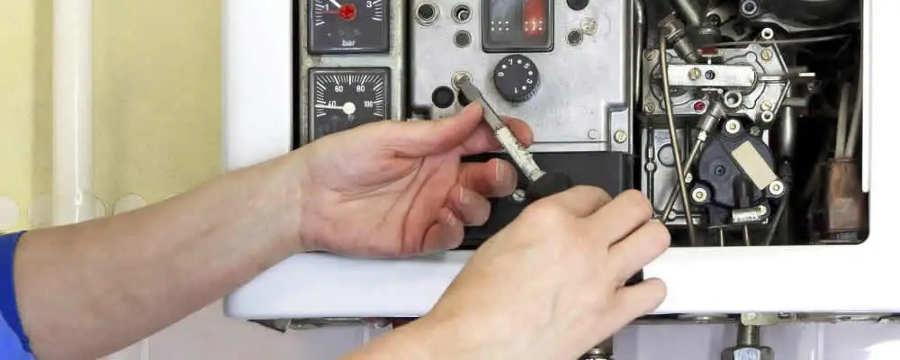 Heating repair technician adjusting boiler controls and components in Salt Lake City, UT