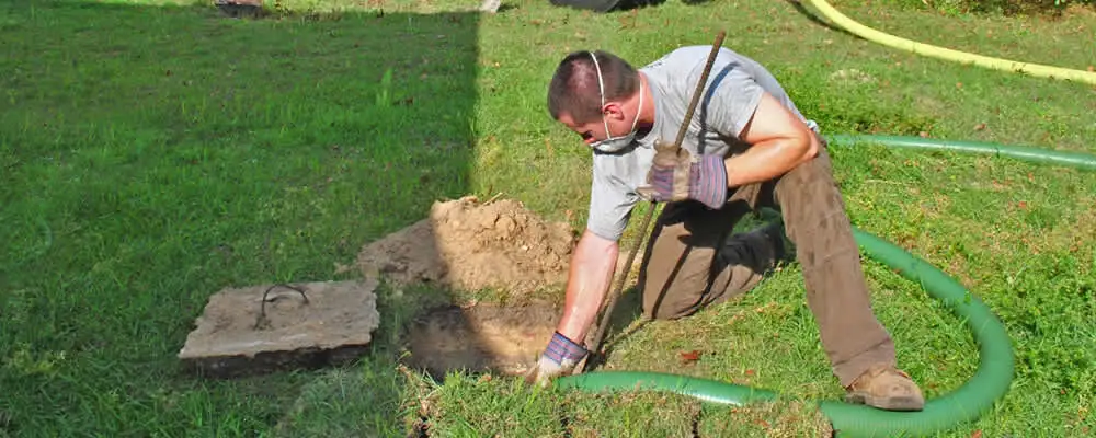 Septic pumping technician servicing a residential septic tank in Salt Lake City, UT