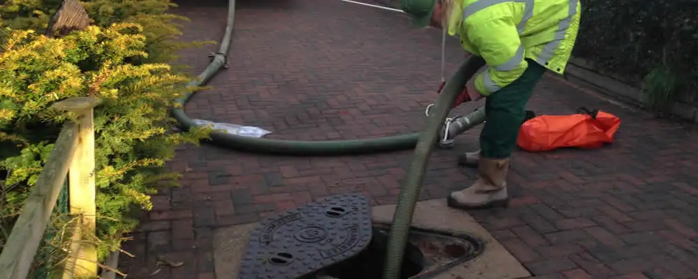 Septic tank cleaning technician servicing a septic tank with a vacuum hose in Salt Lake City, UT
