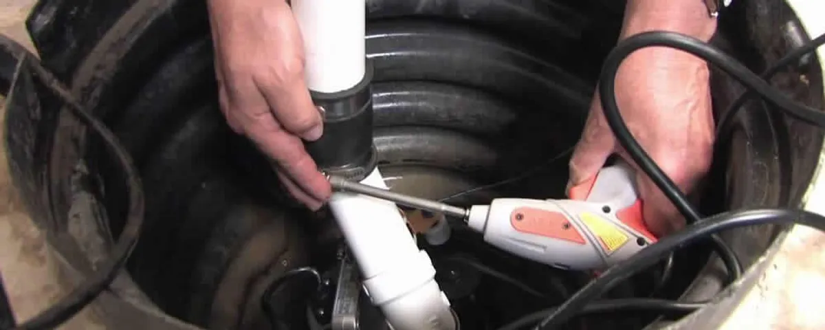 Sump pump installation technician connecting PVC discharge piping in Salt Lake City, UT