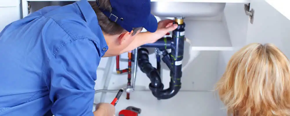 Plumber repairing under-sink drain pipes and fittings in Salt Lake City, UT